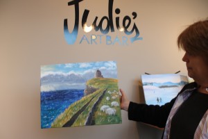 Owner Katie Day displays one of her recent paintings.